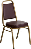HERCULES Series Trapezoidal Back Stacking Banquet Chair with Brown Vinyl and 2.5'' Thick Seat - Gold Frame